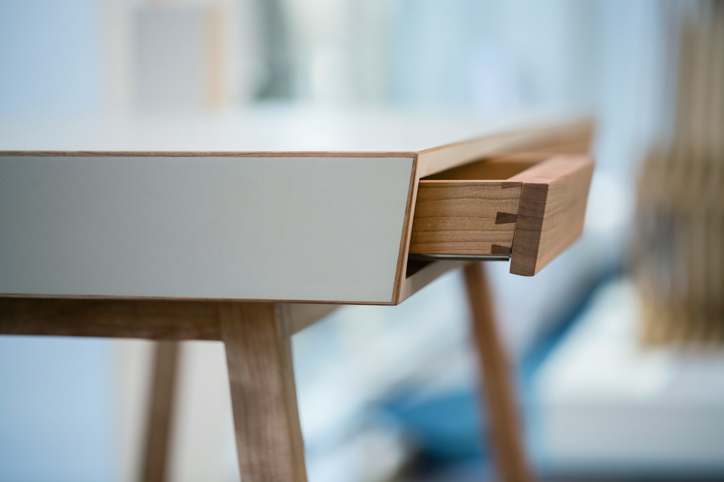 Modern wooden desk drawer showing dovetail joinery.