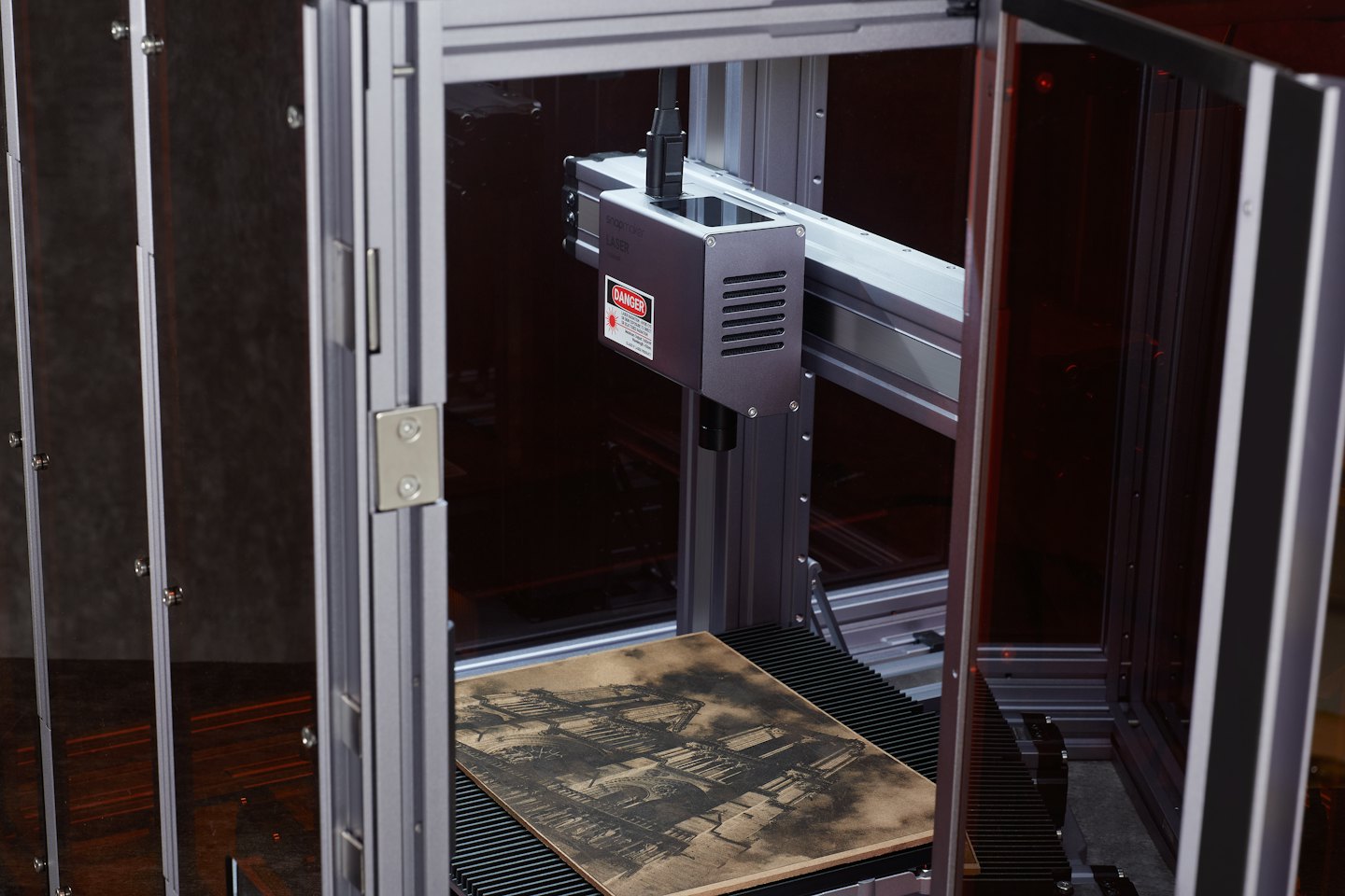 Laser engraving machine with intricate design on wood.
