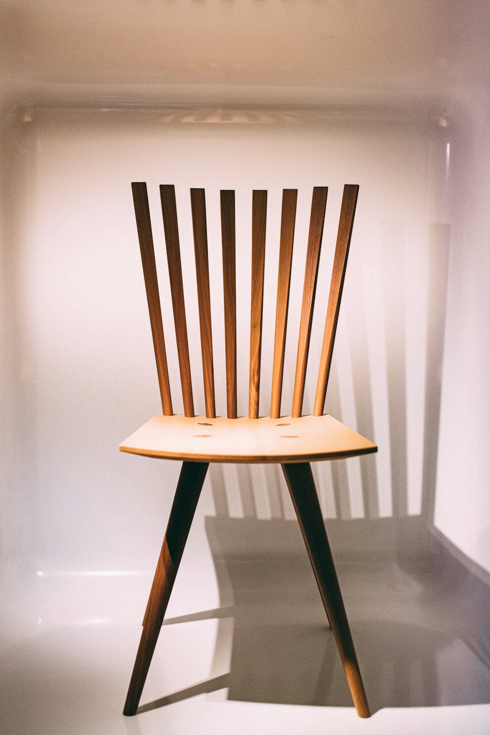 Modern wooden chair with slatted back and contoured seat.